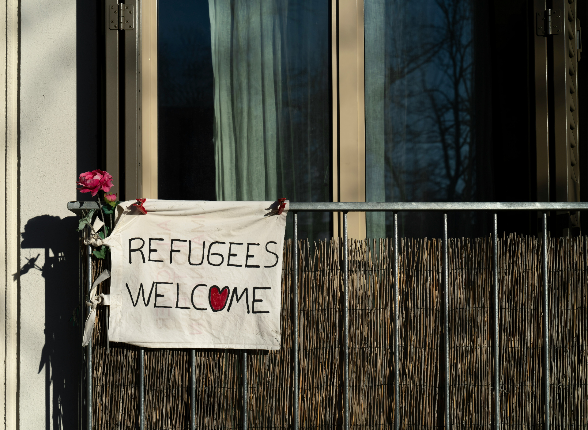 Banner on a balcony reading refugees welcome